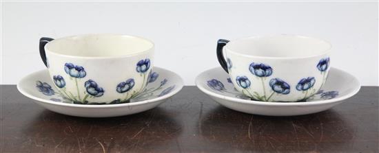 Two Macintyre Burslem Blue Poppy pattern white ground cups and saucers, early 20th century saucer 14cm, one cup and saucer restored